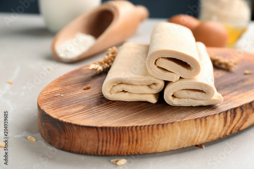 Fototapeta Naklejka Na Ścianę i Meble -  Wooden board with fresh dough on table. Puff pastry