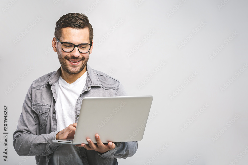 Confident business expert. Confident young handsome man in shirt holding laptop and smiling while standing against white background