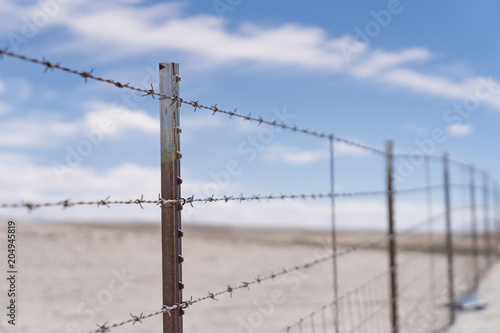 Barb wire fence in the dry desert country with metal post