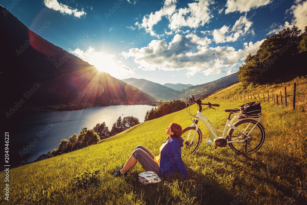 Naklejka premium woman on e-bike enjoying view to a beautiful lake