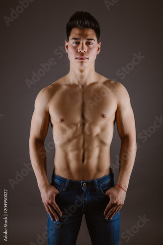 Handsome topless man standing in jeans photo