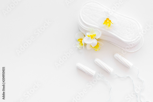 Woman hygiene protection. Cotton tampons and sanitary pads on white background top view copy space