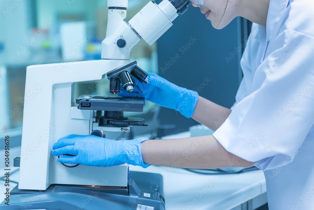 Young asian scientist looking through a microscope in a laboratory.Thailand people doing some research. Young asian scientist looking through a microscope in a laboratory.Thailand people doing some research.