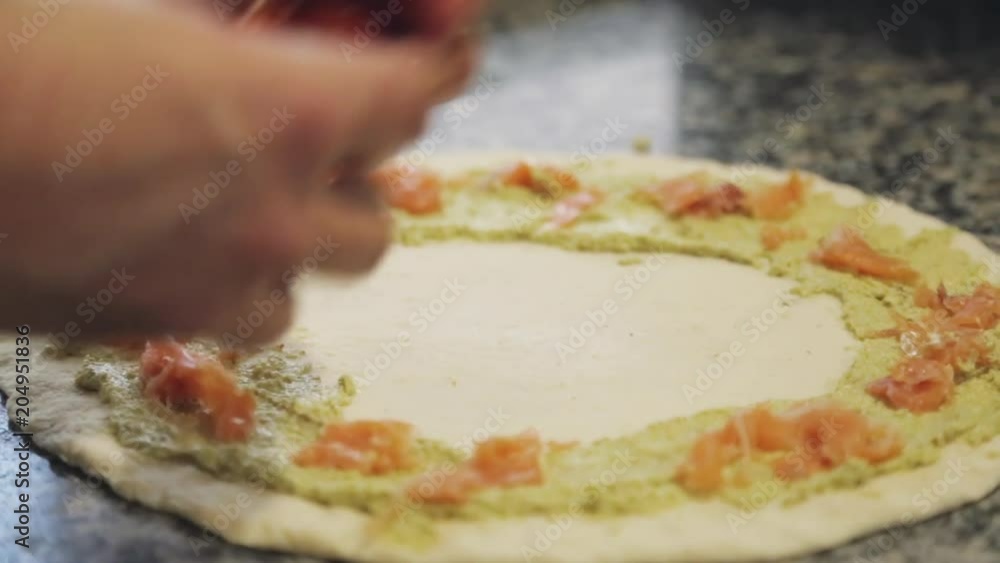 Close up, chef adds tomatoes to pizza dough Close up, chef adds tomatoes to pizza dough