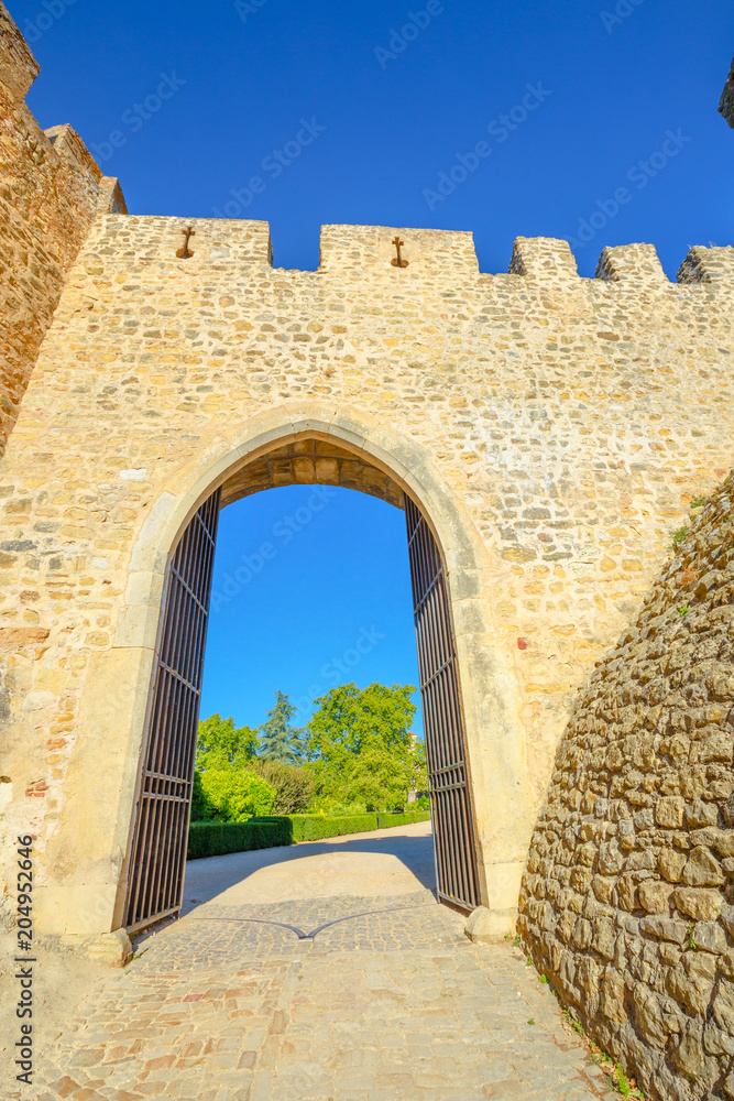 Sun door in Tomar Fortress, Portugal, Unesco Heritage. Tomar convent-fortress was part of a defensive system created by Knights of Hordes of the Templars. Summer season, blue sky. Vertical shot.