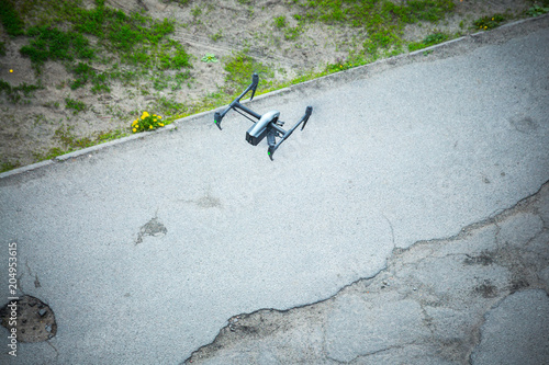 Quadcopter UAV`s drone for commercial aerial photography flying over old asphalt road examines exploring the defects of the road surface. photo