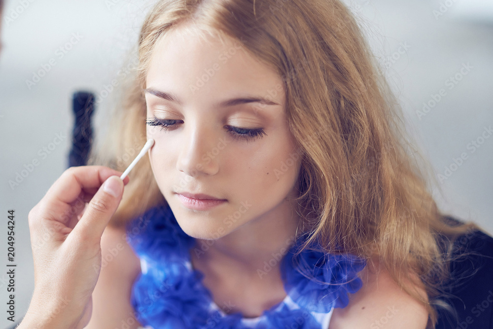 Obraz premium Stylist doing the make-up for a beautiful little girl model.