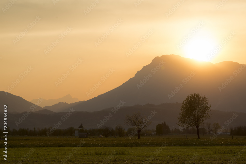 Beautiful sunset in rural area of Meduno, Italy with high mountains on the background.