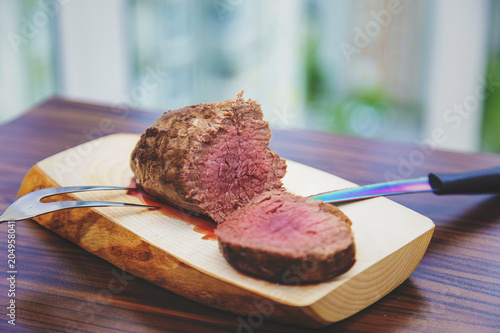 Rare underdone sliced rib beef ober wooden plate