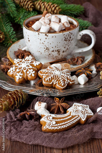 Cup of creamy hot chocolate with melted marshmallows and gingerbread cookies for christmas holiday