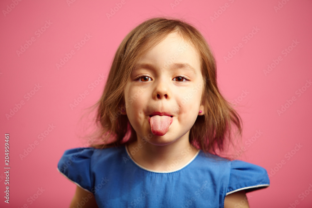 Little girl showing tongue at the camera. Little girl showing tongue at the camera.