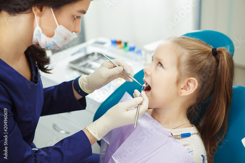 Child lies in dentist chair and goes through procedure