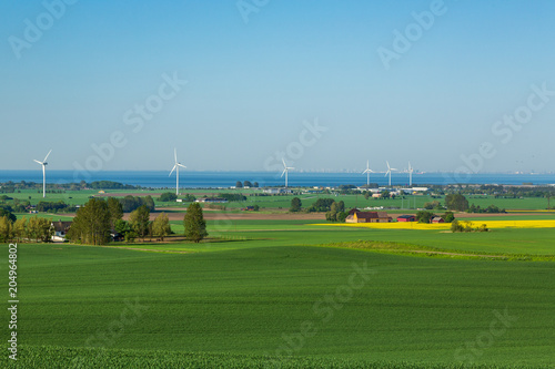 Utsikt över åker, vindkraftverk och Öresund