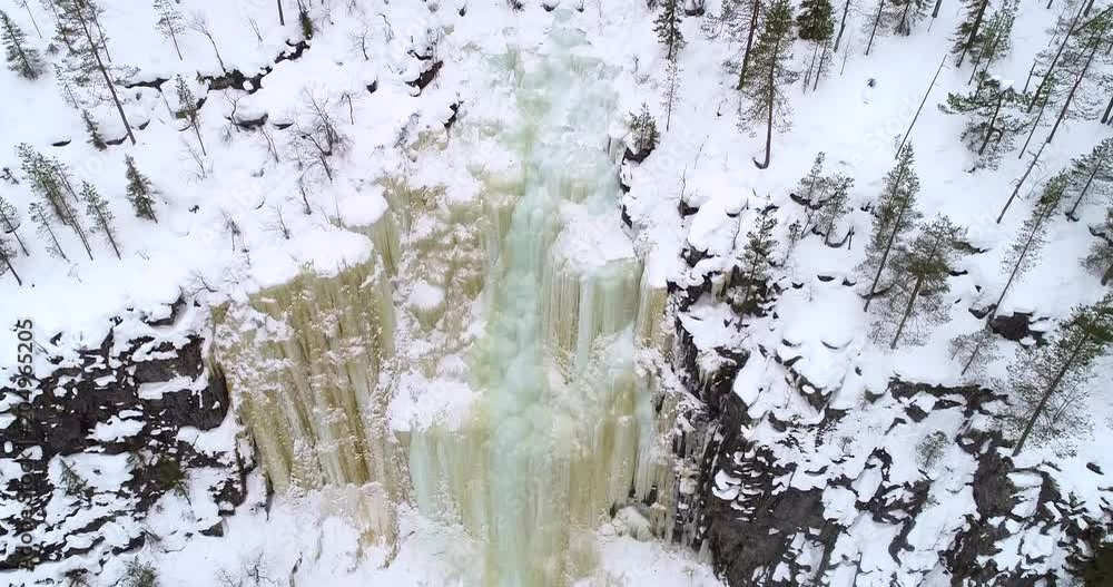 Ice falls, C4k aerial rising tilt view of a colorful ice wall or waterfall, in korouoma national reserve, on a cold, cloudy winter day, in Posio, Lapland in North Finland Ice falls, C4k aerial rising tilt view of a colorful ice wall or waterfall, in korouoma national reserve, on a cold, cloudy winter day, in Posio, Lapland in North Finland
