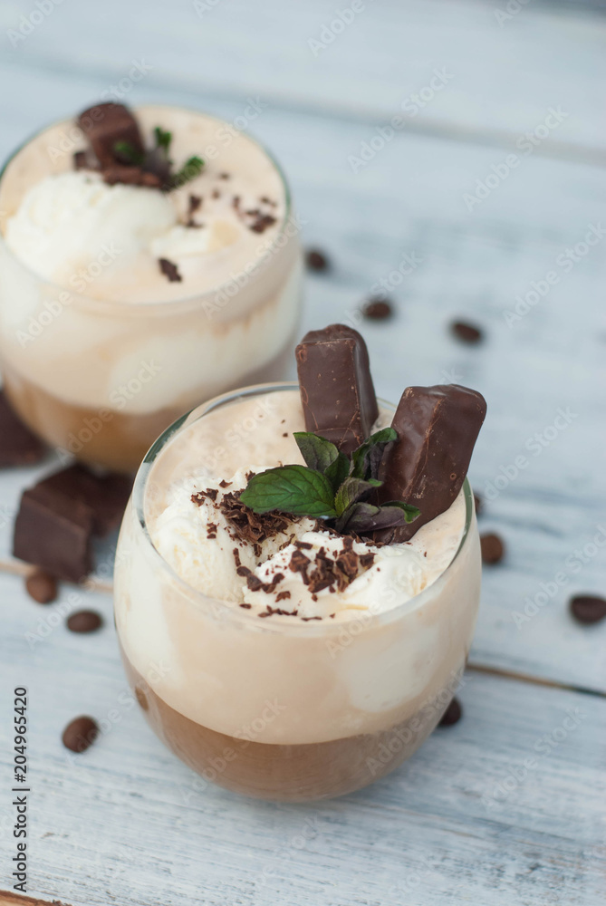 Iced Mocha Frappe Coffee with Whip Cream, Summer Drinking times. Coffee Beans. rustic textured Wooden Background. Mint Leaves Iced Mocha Frappe Coffee with Whip Cream, Summer Drinking times. Coffee Beans. rustic textured Wooden Background. Mint Leaves