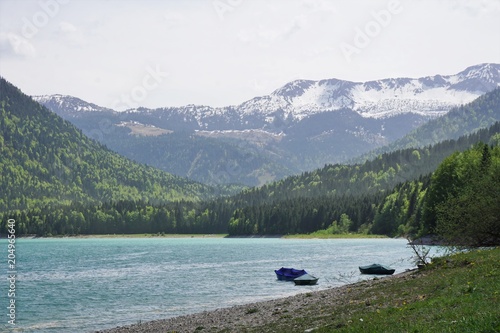 Very blue lake in the mountains of Bavaria in Germany with forrest © Janin