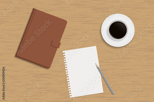 Hardcover notebook, cup of coffee and a white sheet of paper with a pencil on a wooden table top - with space for your text