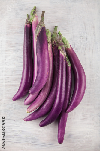 Fresh, beautiful purple violet eggplants decorated on a white wood table, studio shoot can be used as background