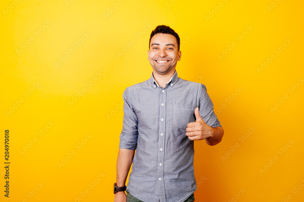 cheerful young afro american man showing thumbs up and smiling over yellow background cheerful young afro american man showing thumbs up and smiling over yellow background