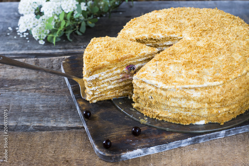 Russian honeycake medovik on wooden table and white background. Cake with berries. Currant cake photo