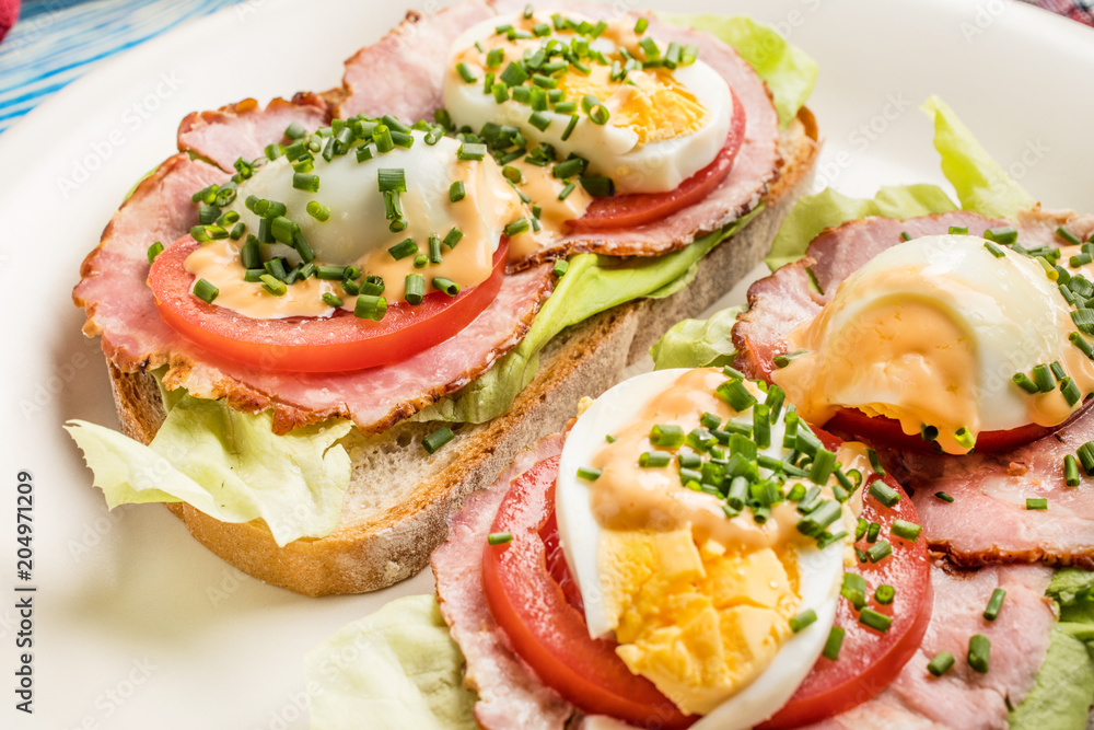 Sandwich with tomatoes, eggs and lettuce.