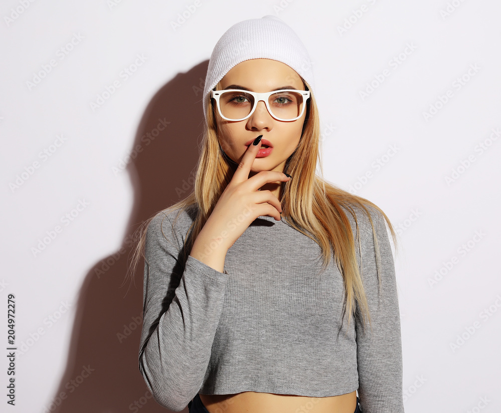 Fototapeta premium Lifestyle and people concept: Young cute smiling hipster girl wearing white glasses and hat. Emotion on face.