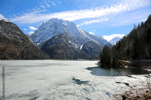 frozen little alpine lake called Lago del Predil in Italian Lang photo