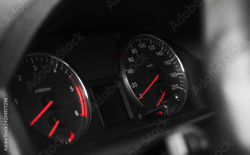 Car dashboard with speedometer on black