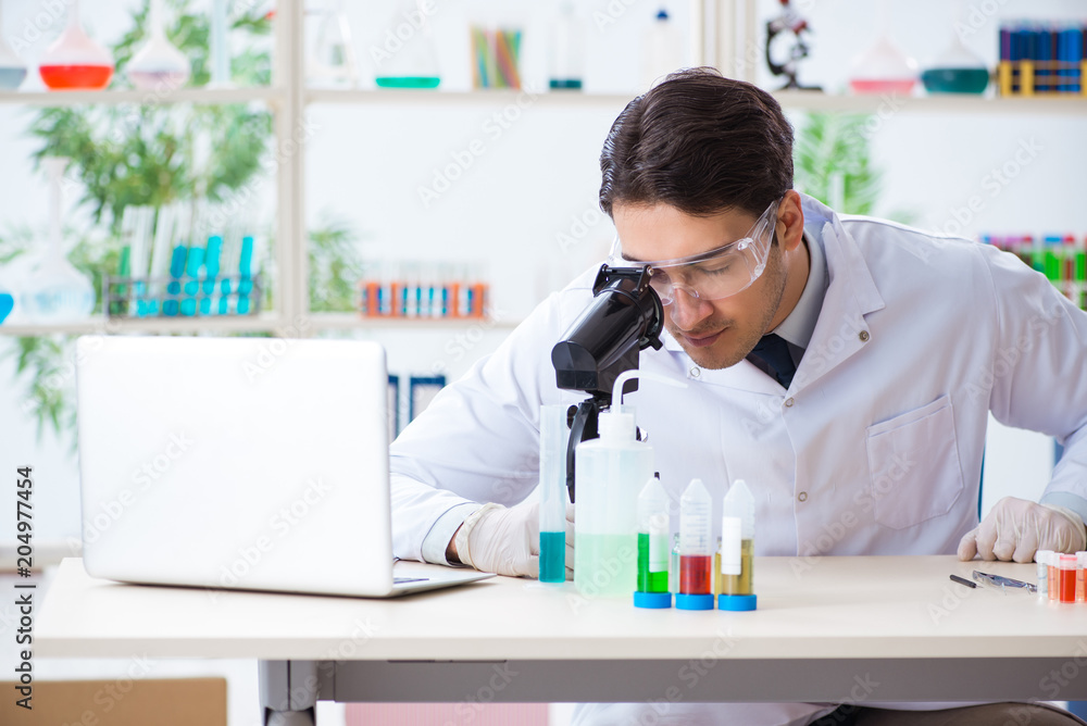Male biochemist working in the lab on plants Male biochemist working in the lab on plants