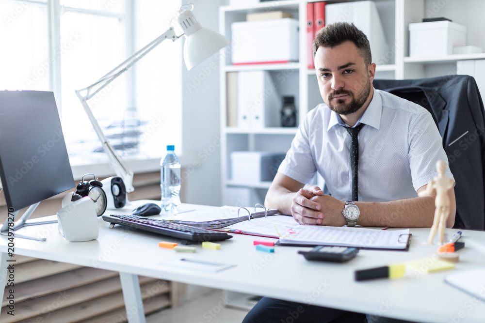 A man is sitting at a table in the office. A man is sitting at a table in the office.