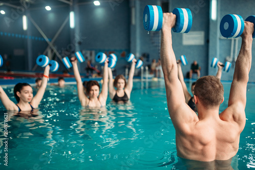 Fototapeta Naklejka Na Ścianę i Meble -  Class with trainer on workout with aqua dumbbells