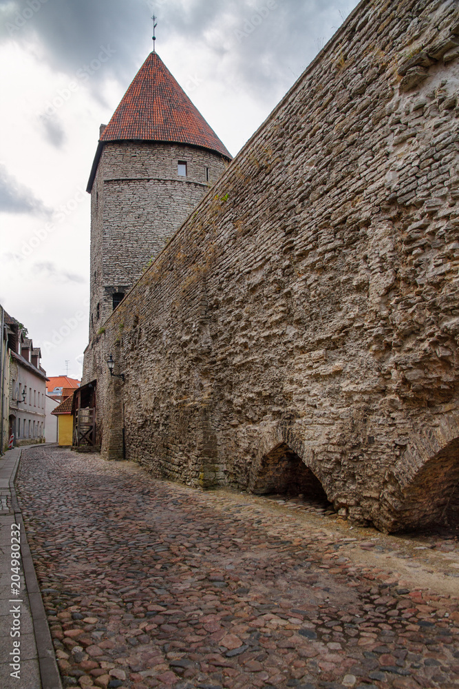 Street of the old town with stone tower of Tallinn in Estonia