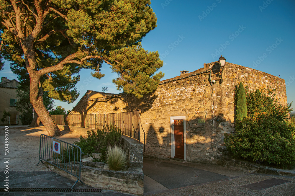 View of traditional stone houses and walls on a street at sunset, in Chateauneuf-de-Gadagne. Located in the Vaucluse department, Provence-Alpes-Côte d'Azur region, southeastern France