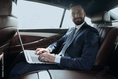young businesswoman working on her laptop while sitting in the car © ASDF