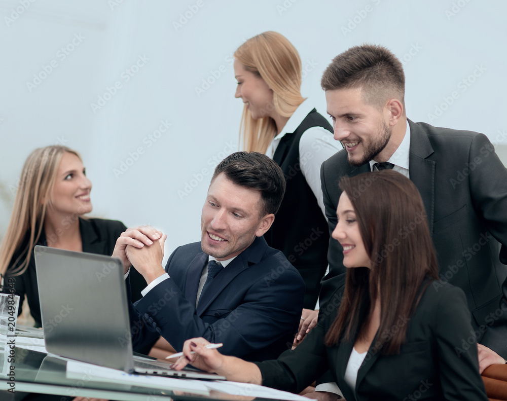 business team discussing new information , standing in front of the open laptop business team discussing new information , standing in front of the open laptop