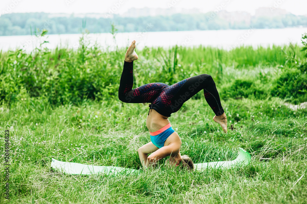 Fototapeta premium Fitness sport girl in fashion sportswear doing yoga fitness exercise on carimate outdoor