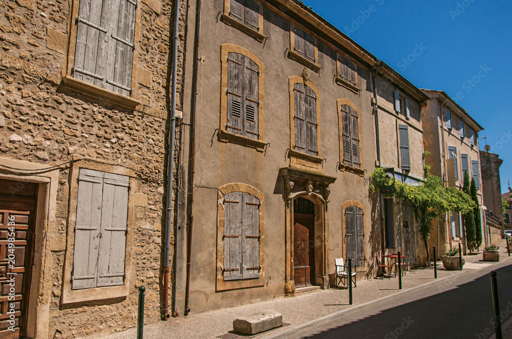 View of typical stone houses and shops on a street of the historical village of Lourmarin. Located in the Vaucluse department, Provence-Alpes-Côte d'Azur region, southeastern France