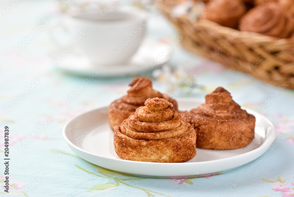 Cinnamon buns with tea and spring flowes Cinnamon buns with tea and spring flowes