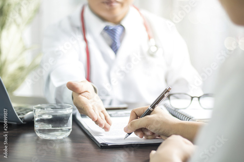 Obraz na plátně Doctor introduces patient signing on medical records before treat illness in hos