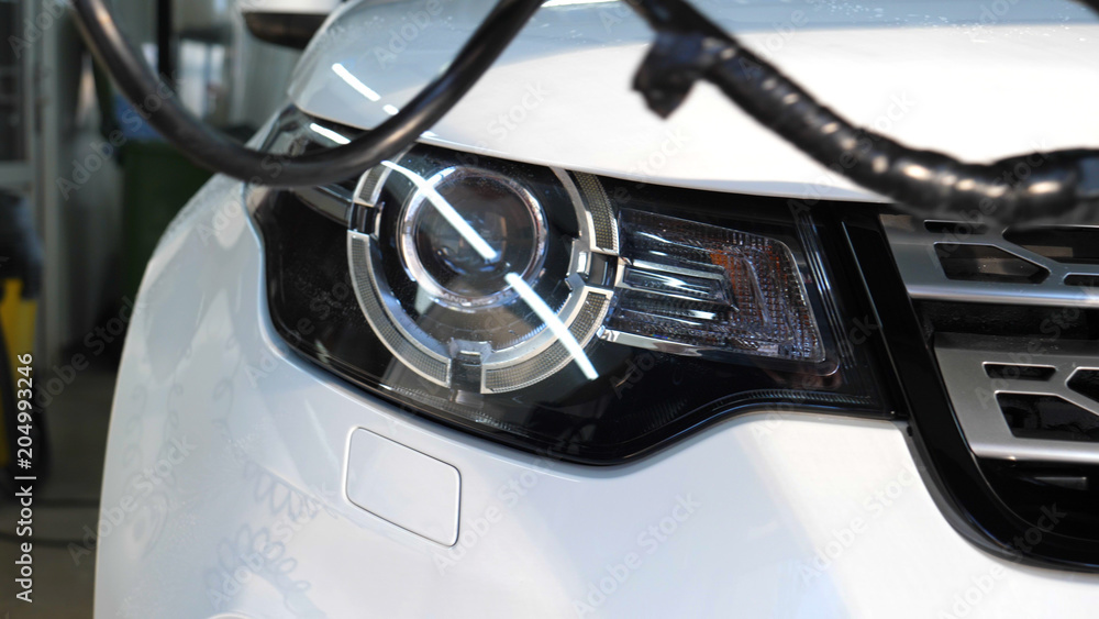 Car on a car wash, close-up headlight