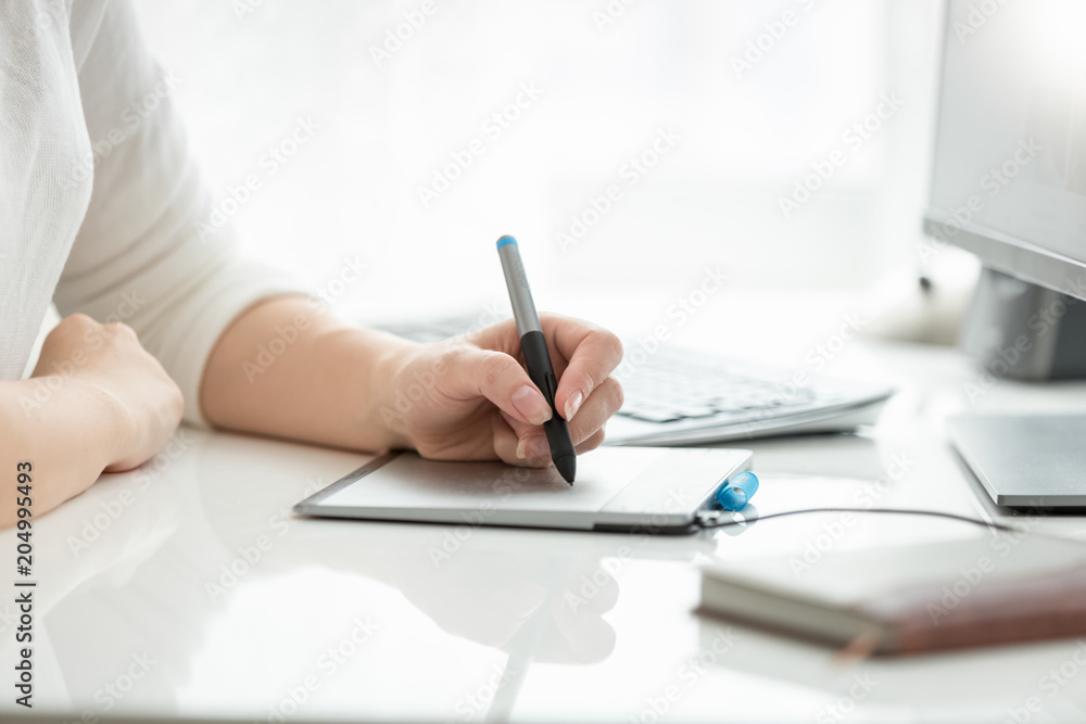 Fototapeta premium Closeup image of female hand drawing with stylus on graphic tablet