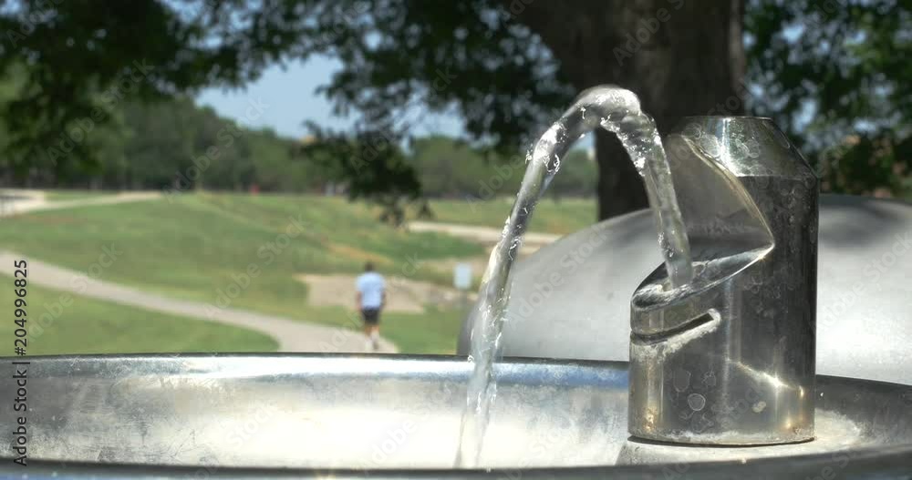 Drinking fountain in a park with people in background. Drinking fountain in a park with people in background.