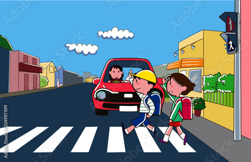 横断歩道を手を上げて渡る小学生と停止している自動車