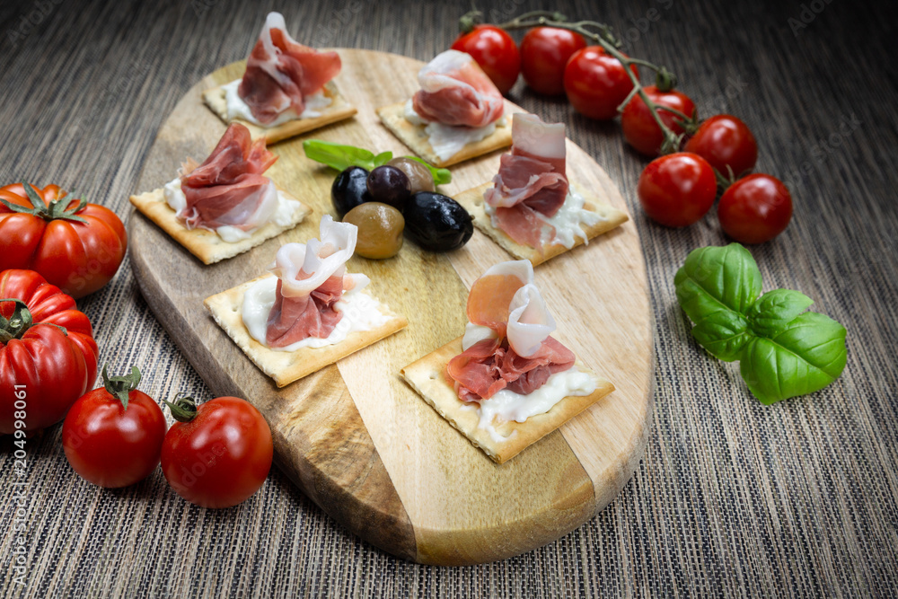 An appetizer of Italian ham, artisan stracchino and olives from Puglia (Italy). It is a very tasty typical appetizer. An appetizer of Italian ham, artisan stracchino and olives from Puglia (Italy). It is a very tasty typical appetizer.