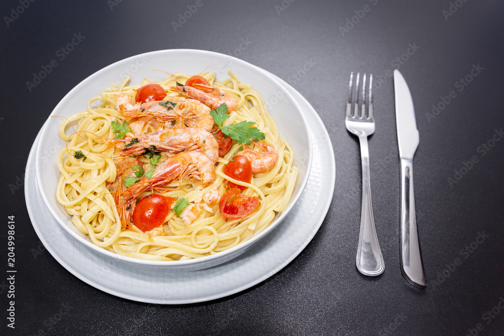 Linguine with shrimps and cherry tomatoes. The shrimps of the Mediterranean are precious crustaceans, the sauce is also accompanied by pepper and fresh parsley Linguine with shrimps and cherry tomatoes. The shrimps of the Mediterranean are precious crustaceans, the sauce is also accompanied by pepper and fresh parsley