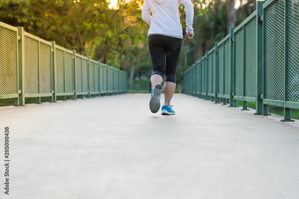 young fitness woman legs walking in the park outdoor, female runner running on the road outside, asian girl jogging and exercise on footpath in sunlight morning. healthcare and well being concepts young fitness woman legs walking in the park outdoor, female runner running on the road outside, asian girl jogging and exercise on footpath in sunlight morning. healthcare and well being concepts