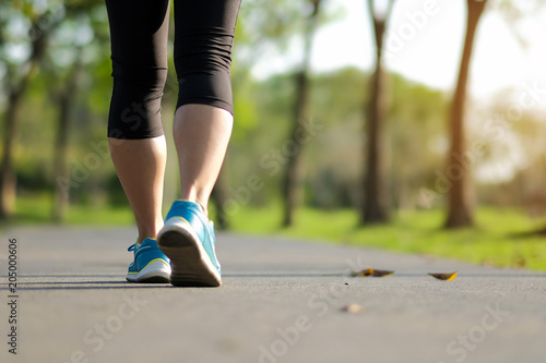 young fitness woman legs walking in the park outdoor, female runner running on the road outside, asian girl jogging and exercise on footpath in sunlight morning. healthcare and well being concepts © Jo Panuwat D