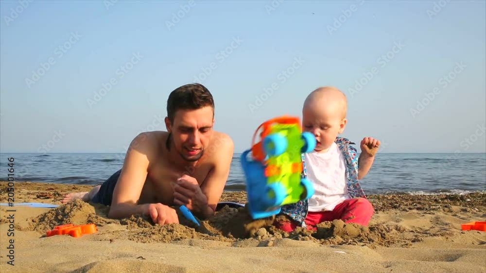 young father and child playing with sand on the beach. Russia, the Japanese Sea.
young father and child playing with sand on the beach. Russia, the Japanese Sea.