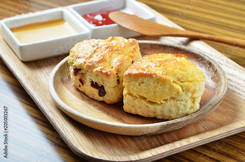 Scone with jam on wooden plate