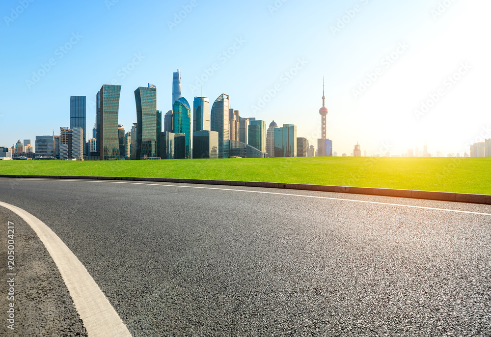 empty asphalt road and city skyline in shanghai at sunset